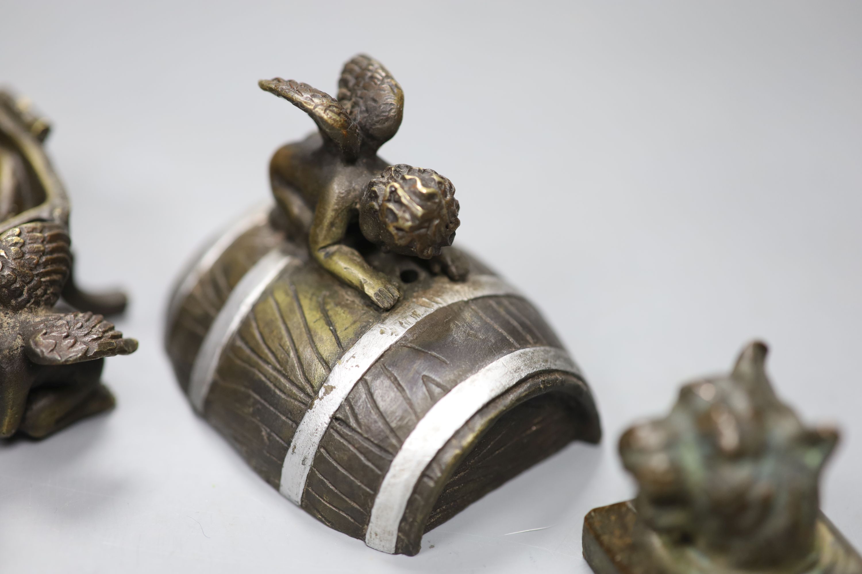 Two novelty bronze seals and novelty bronze cherub group, height 9cm